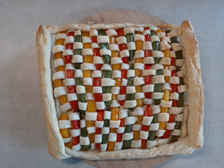 Zapiekanka z mięsa mielonego i ciasta francuskiego, ozdobiona kolorową mozaiką z papryki